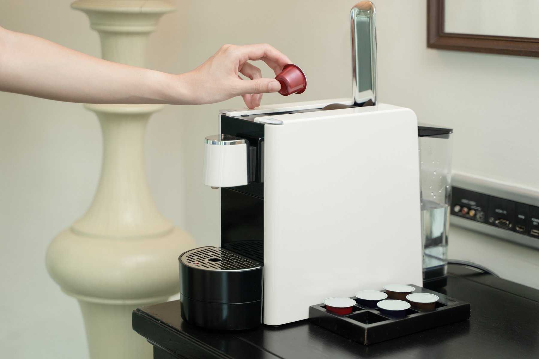 Person Putting Coffee Capsule on Coffee Maker